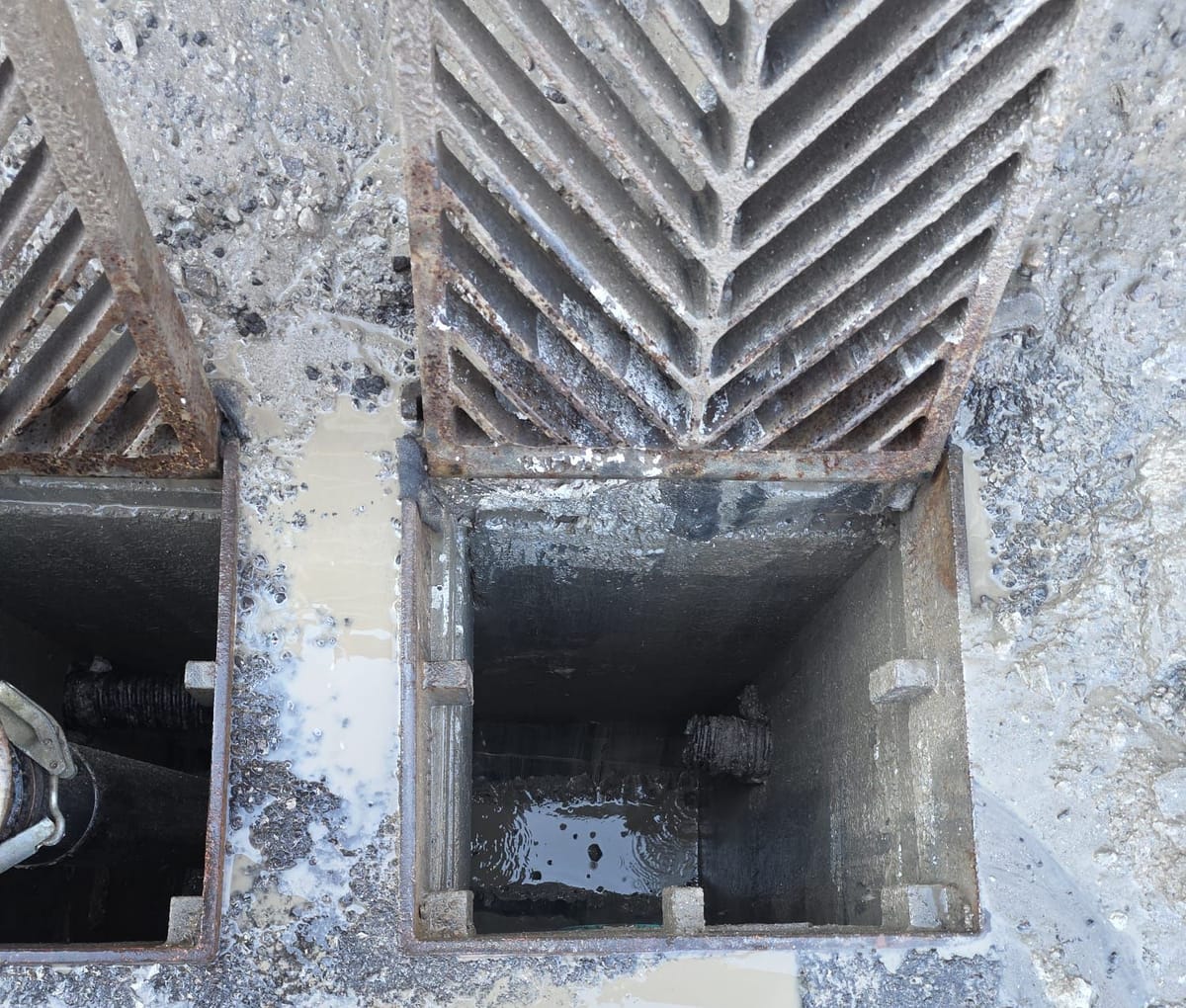 Catch basin with its grate lifted and the chamber vacuumed clean of sediment